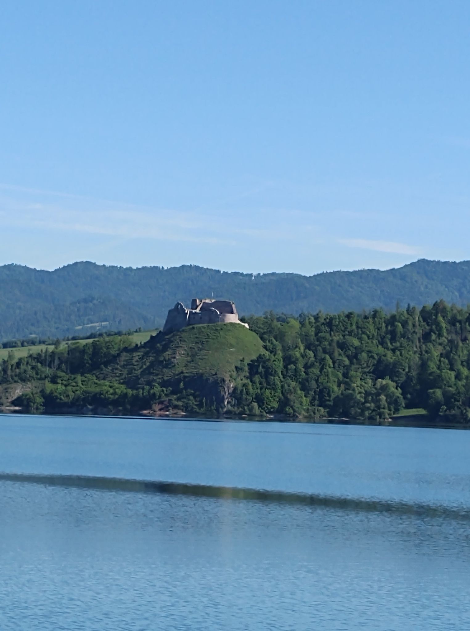 Zdjęcie przedstawia widok ruin Zamku Czorsztyńskiego na tle jeziora