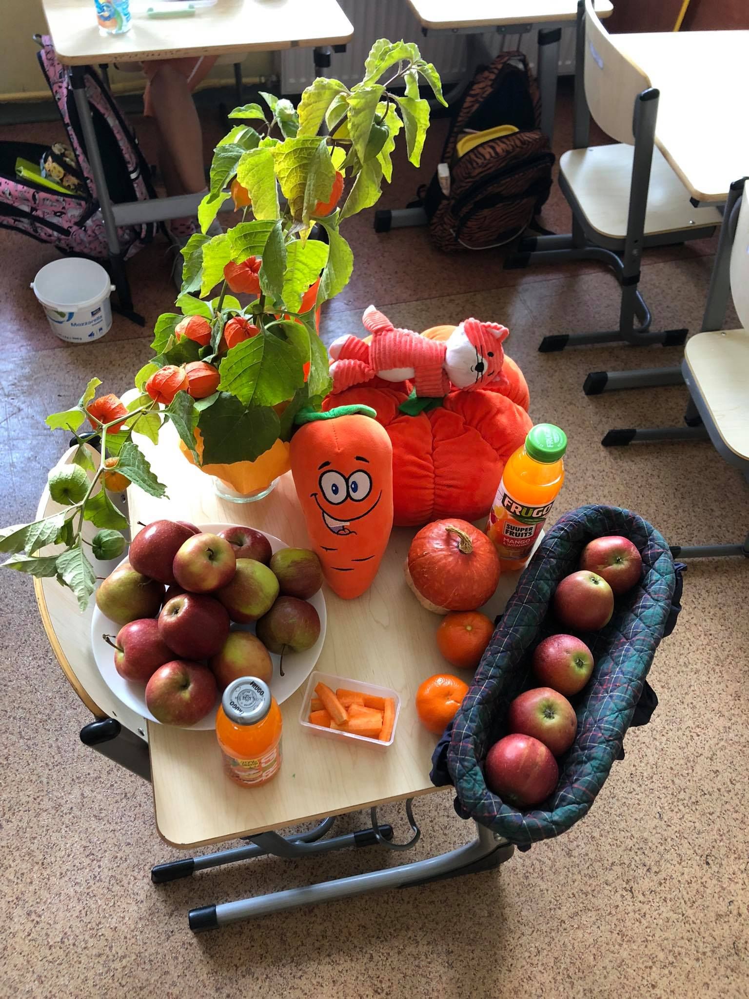 Zdjęcie przedstawia jabłka i i zdrowe produkty w kolorze pomarańczowym ułożone na stoliku.